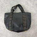 Black mini handbag with studded patchwork handle.