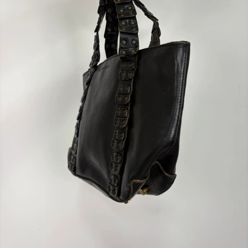 Black mini handbag with studded patchwork handle.